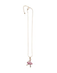 The Ballerina Charm Necklace features a gold-toned adjustable chain and a playful pink lollipop-shaped pendant with a gold stick—a standout accessory from our Ballet Collection.