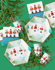 Christmas-themed party supplies such as paper plates, cups, and napkins with nutcracker design on a green background.