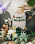 Dinosaur-themed birthday party with balloons, cake, and decorations.