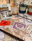 Harry Potter Potions Label Decals, accompanied by a wand, round glasses, and vinyl stickers, are arranged on wood to create a magical, apothecary-style display.