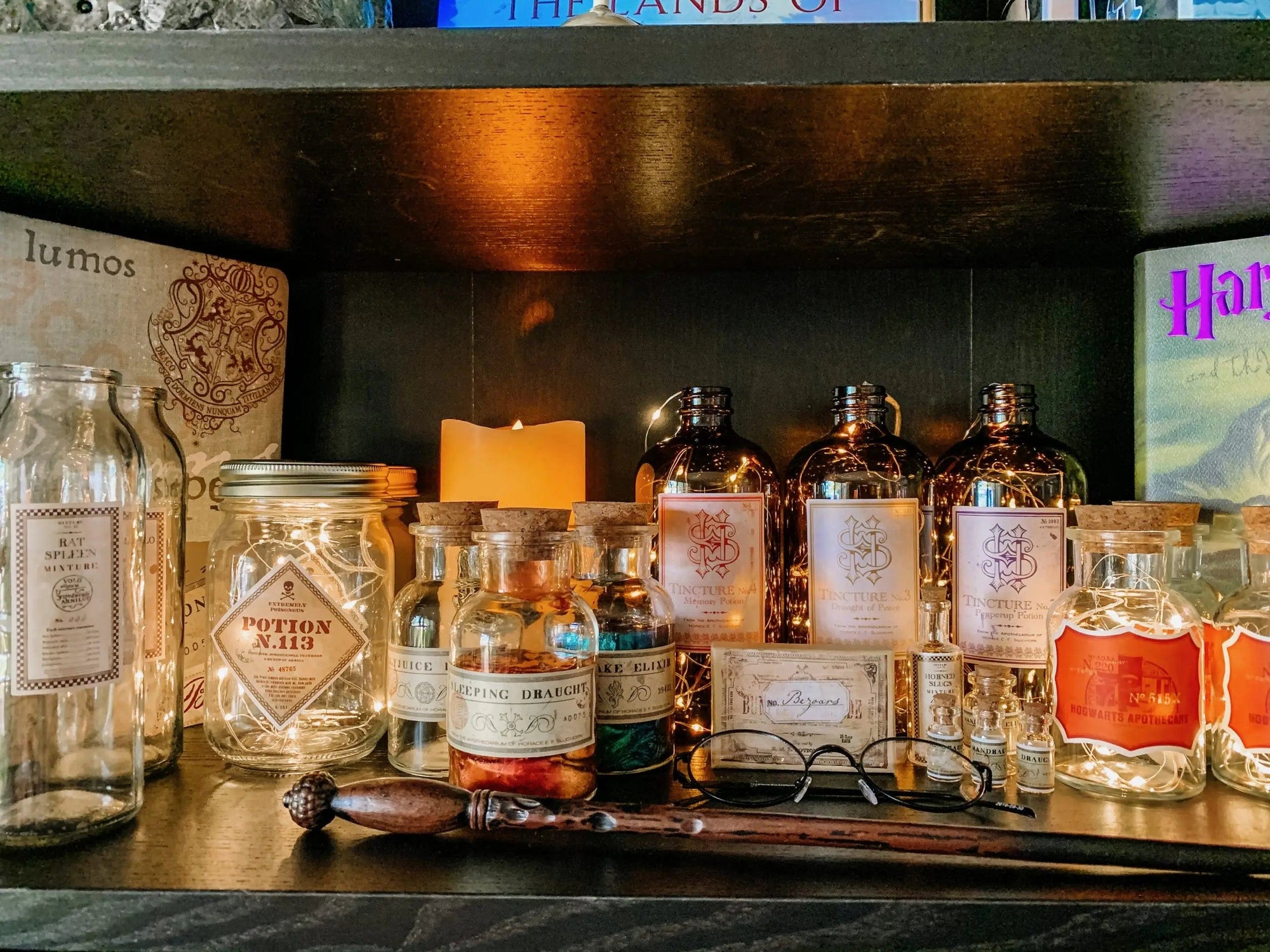 Add a Harry Potter touch to your display with glass bottles labeled using Harry Potter Potions Label Decals, potion descriptions on vinyl stickers, a Potion No. 13 jar, candle, wand, and round glasses for magical charm.