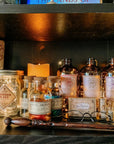 Add a Harry Potter touch to your display with glass bottles labeled using Harry Potter Potions Label Decals, potion descriptions on vinyl stickers, a Potion No. 13 jar, candle, wand, and round glasses for magical charm.