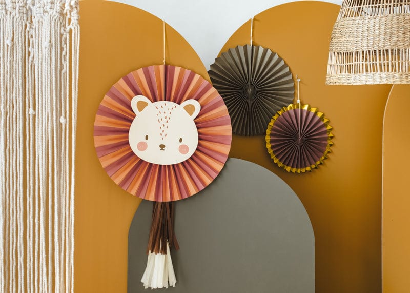 A playful, cozy room features the Party Lion Fan Set—paper lion face and fans—on a mustard wall, paired with a woven lamp and macramé curtain for charming decor.