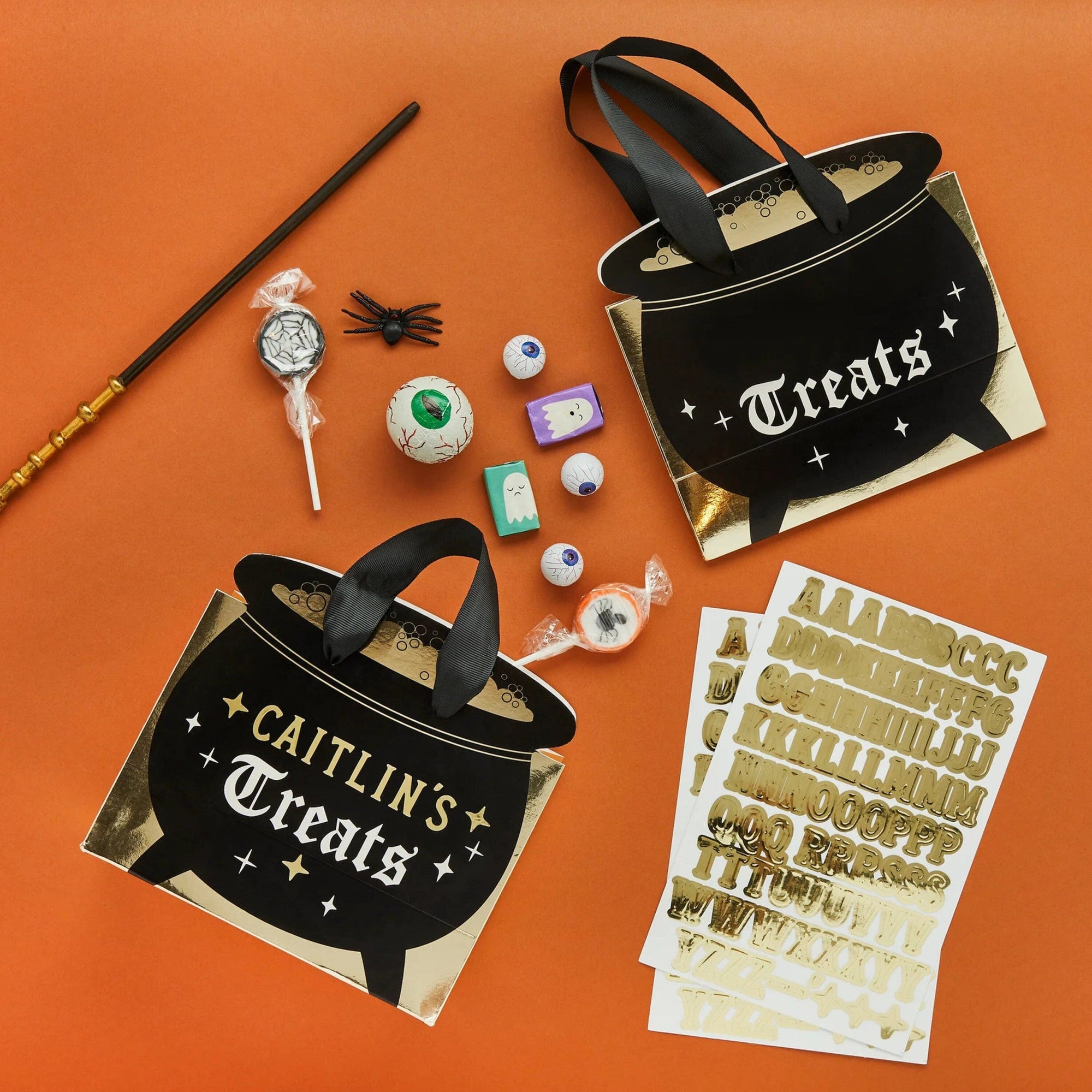 DIY customizable Halloween cauldron loot bags craft kit with gold letter stickers, includes personalization supplies for Halloween party planning and children's party favours