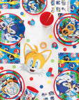 Sonic the Hedgehog party tableware flatlay featuring character plates, cups, napkins with Sonic, Tails, and friends design for children's birthday party