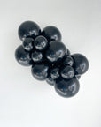 Cluster of black tuftex balloons on a white background