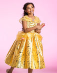Girl wearing Disney Belle prestige costume dress with gold foil skirt, tulle overskirt, and pink bows; Beauty and the Beast princess dress-up gown