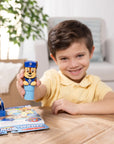 Happy child displaying PAW Patrol Chase sticker stamper collectible toy with activity pages, perfect birthday party gift and entertainment for preschoolers