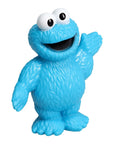 A blue Cookie Monster toy party favour with large white eyes, a wide open black mouth, and one raised waving arm, shown on a plain white background.