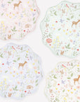 Meri Meri Little Animals plates in pink, mint, lavender and cream pastel watercolour woodland prints. Four scalloped-edge decorative plates arranged on a white background, each with a pastel woodland print featuring deer, birds, flowers, and leaves in soft pink, mint, lavender, and pale blue tones.