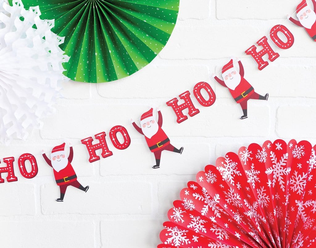 Add festive cheer with the Ho Ho Ho Santa Banner and green, white, and red paper fans featuring cartoon Santa designs, perfect for decorating any space.