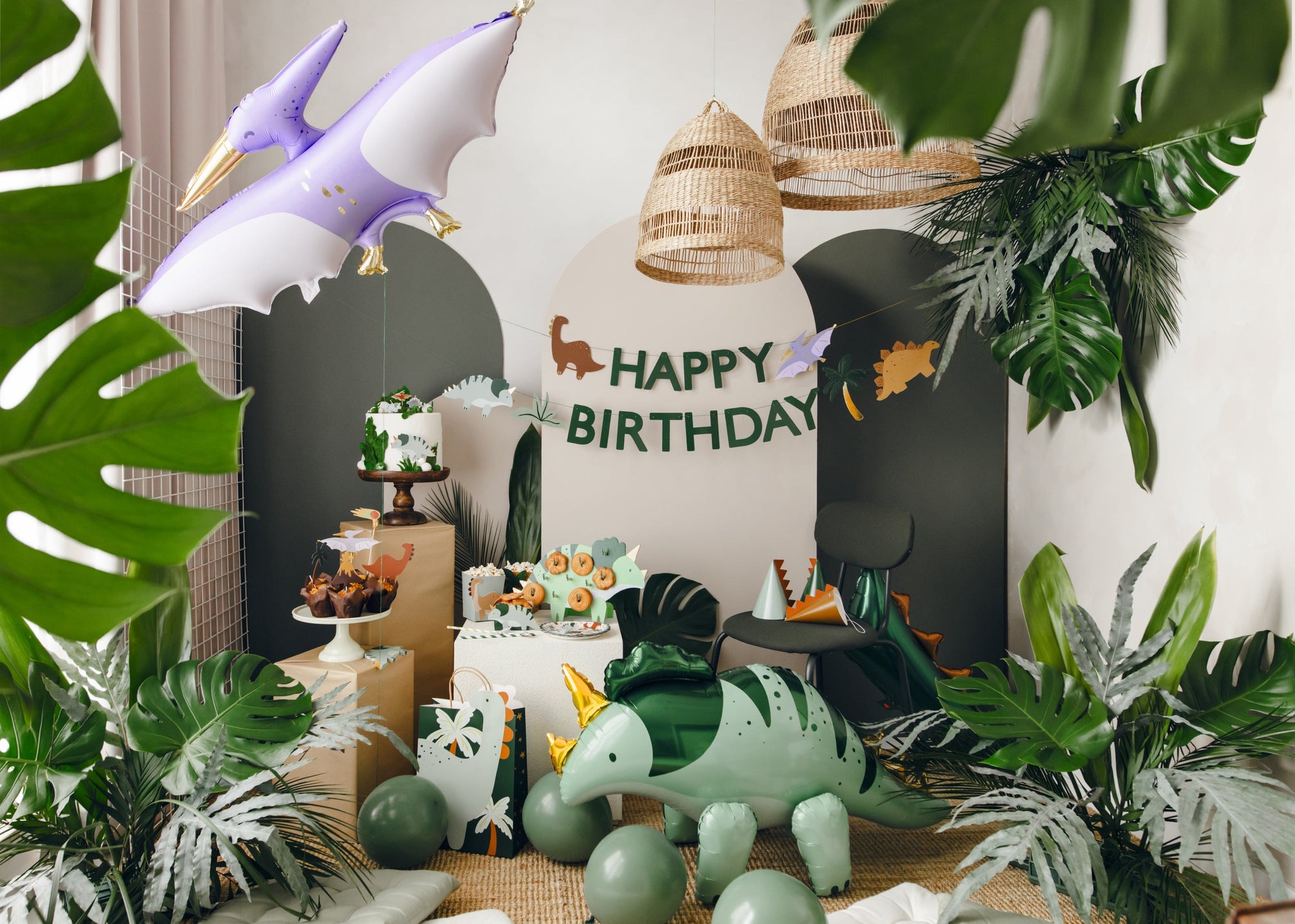 Dinosaur-themed birthday party with balloons, cake, and decorations.