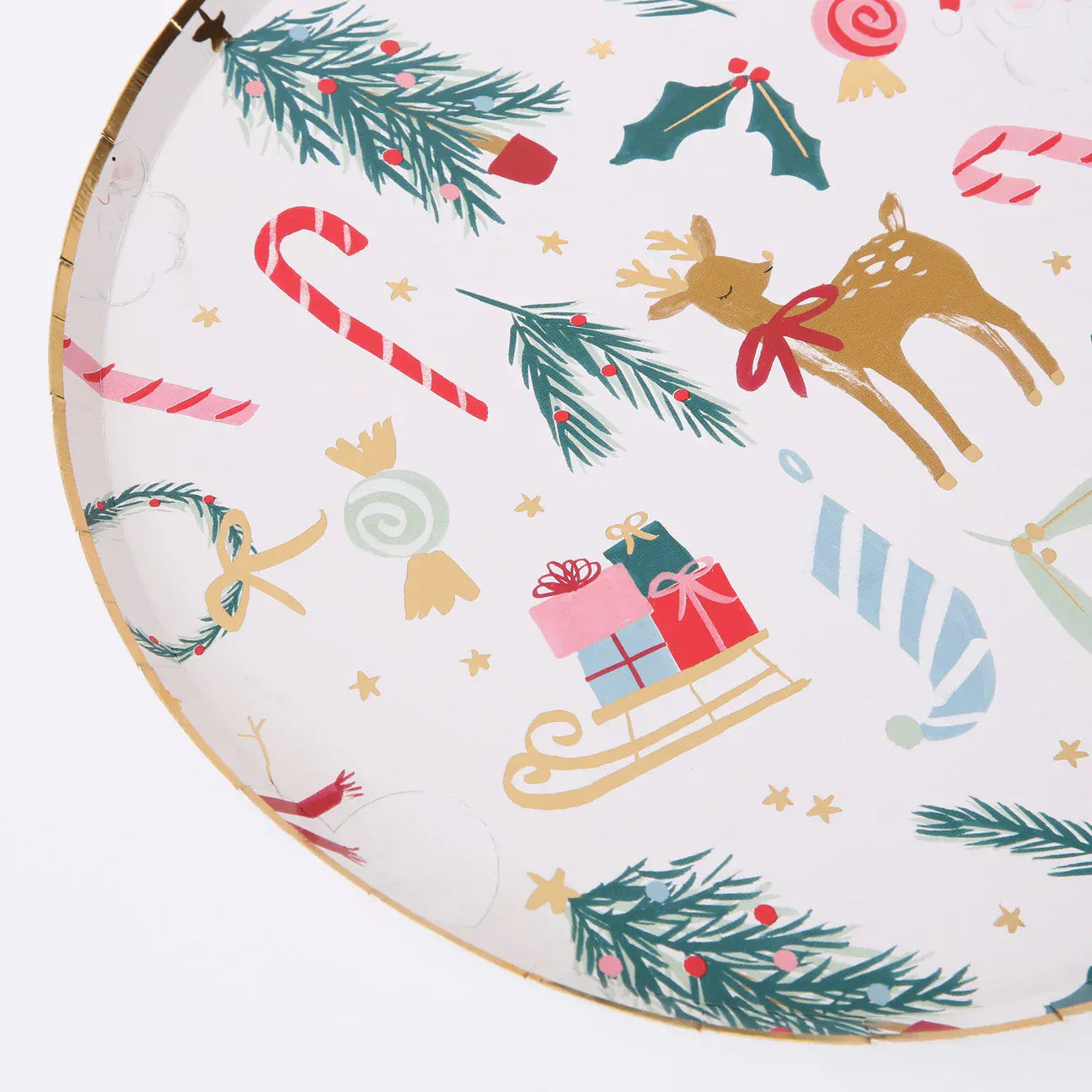 Meri Meri party plate with Christmas-themed illustrations including reindeer, candy canes,snowmen, holly, and presents on a white background.