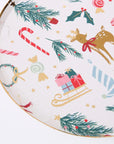 Meri Meri party plate with Christmas-themed illustrations including reindeer, candy canes,snowmen, holly, and presents on a white background.