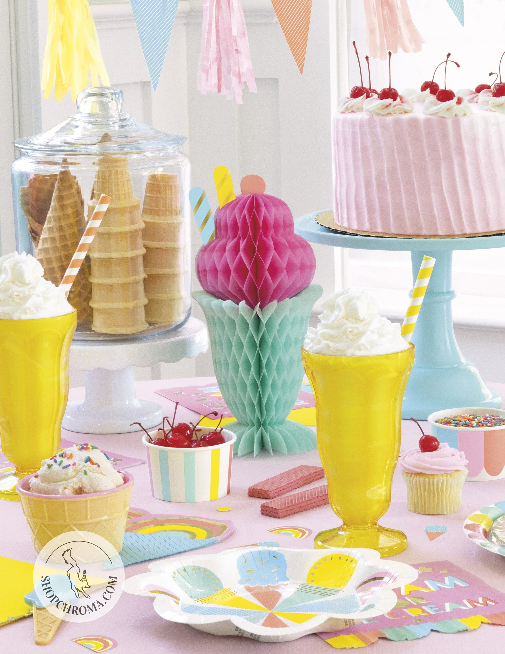 Ice cream sundae birthday party supplies with pastel rainbow plates, yellow sundae glasses, pink cake, waffle cones, tissue paper decorations and sweet treats theme