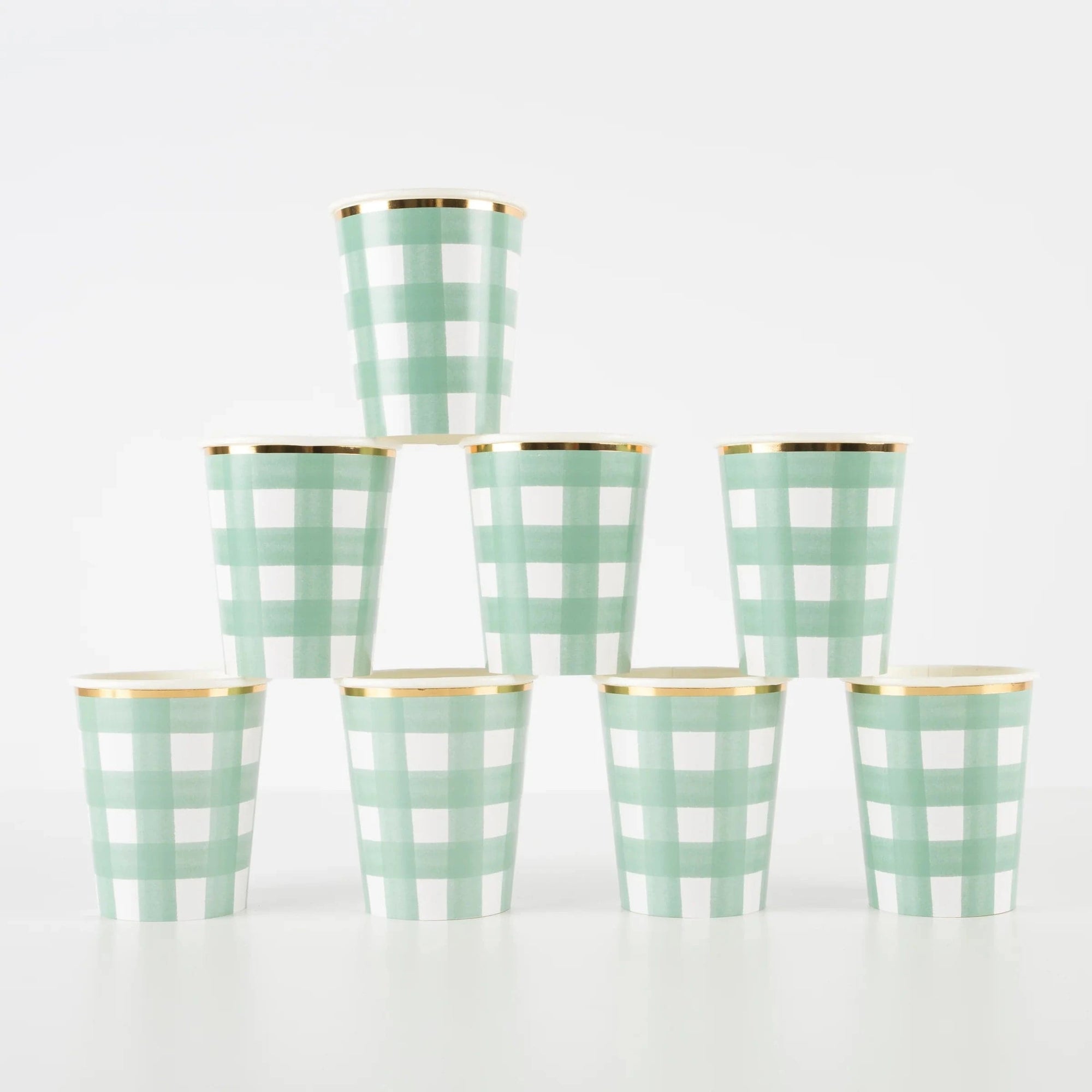 Set of eight green gingham checkered cups with gold rims on a white background