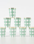 Set of eight green gingham checkered cups with gold rims on a white background