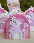 Pink unicorn-shaped favour boxes with rainbow decorative elements 