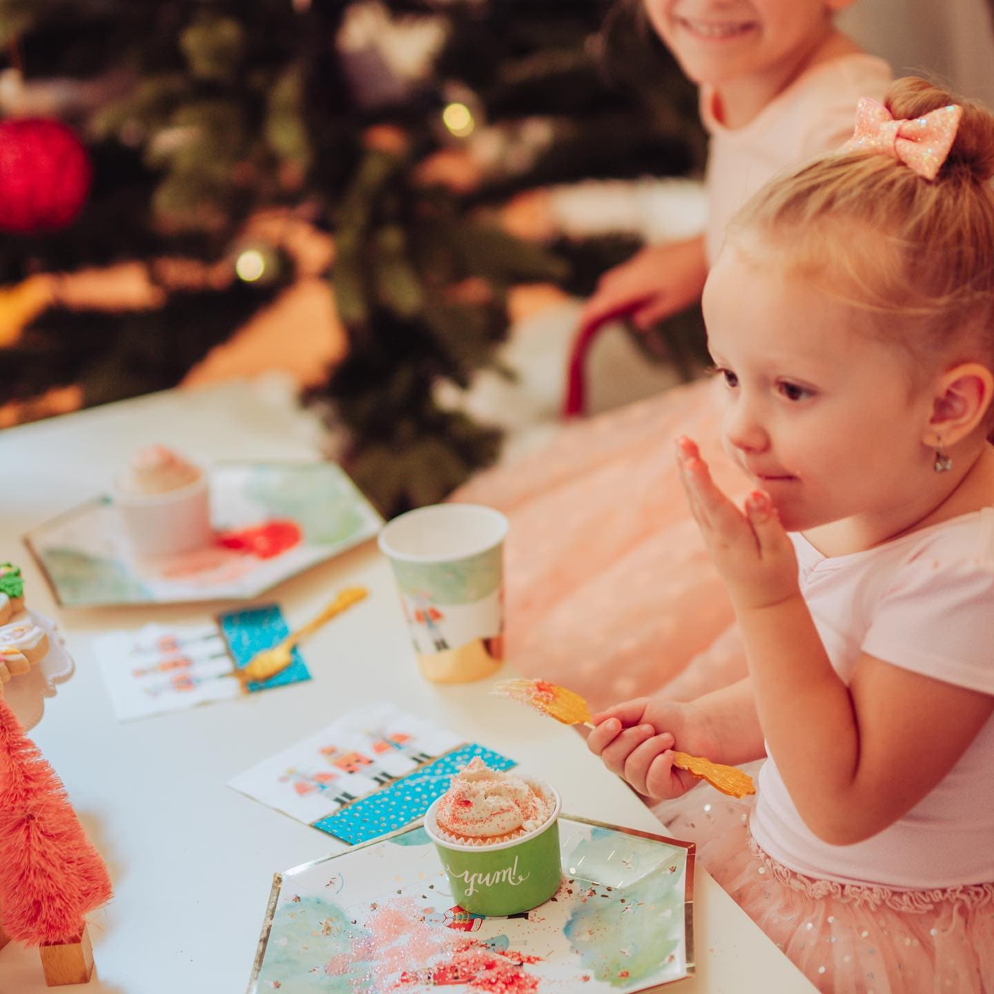 Child at a festive Nutcracker themed party table with Christmas decorations in the background