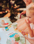 Child at a festive Nutcracker themed party table with Christmas decorations in the background