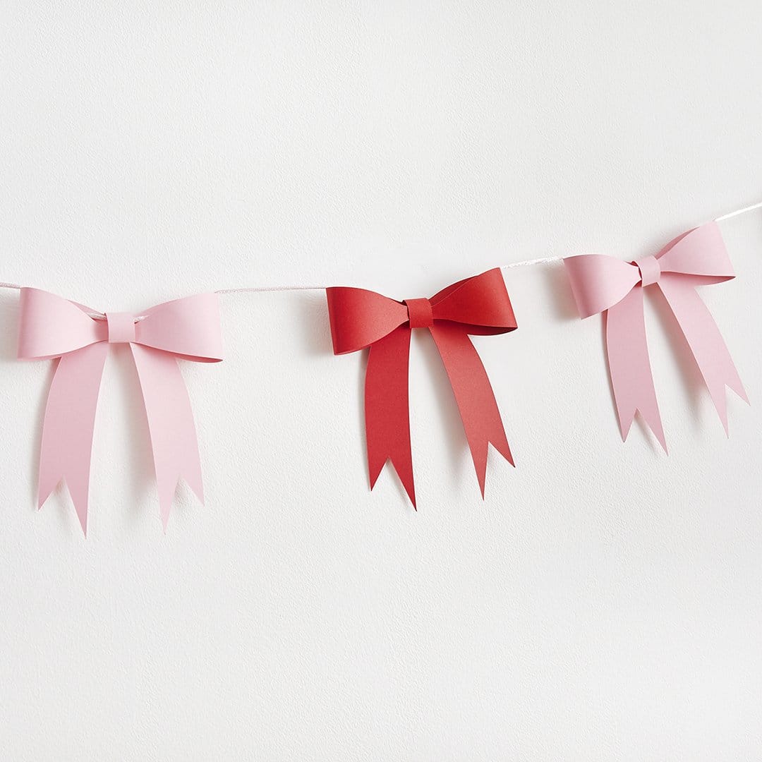 Bunting with pink and red paper bows on a white background