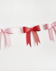 Bunting with pink and red paper bows on a white background