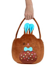 Brown bunny-shaped Squishmallows plush pail with blue ears held by a hand on a white background