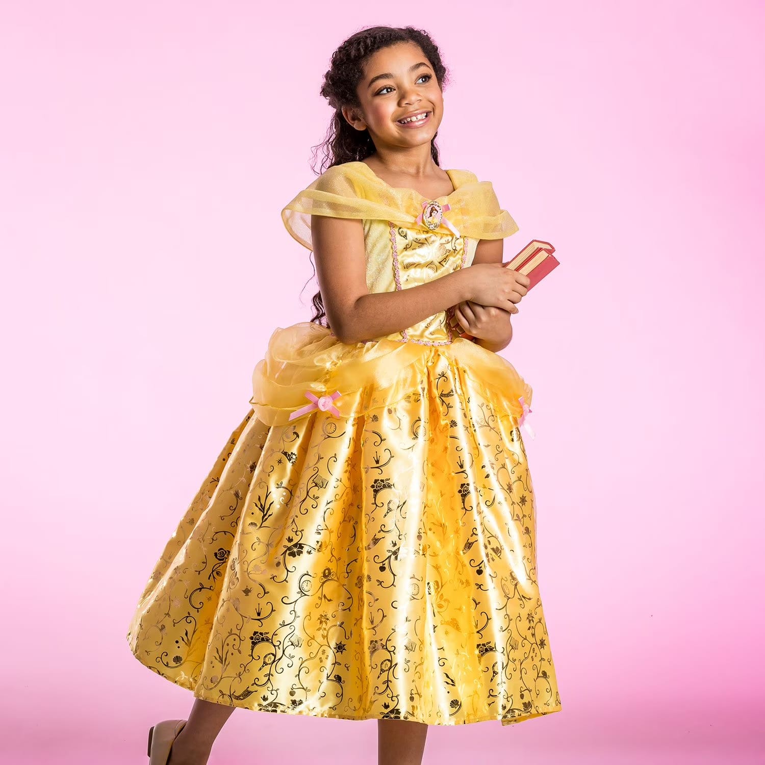 Girl wearing Disney Belle prestige costume dress with gold foil skirt, tulle overskirt, and pink bows; Beauty and the Beast princess dress-up gown
