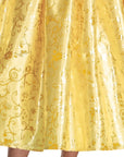 Close-up of Disney Belle costume dress gold foil satin skirt with Beauty and the Beast and Disney Princess icons: roses, enchanted clock, candlestick, and crown