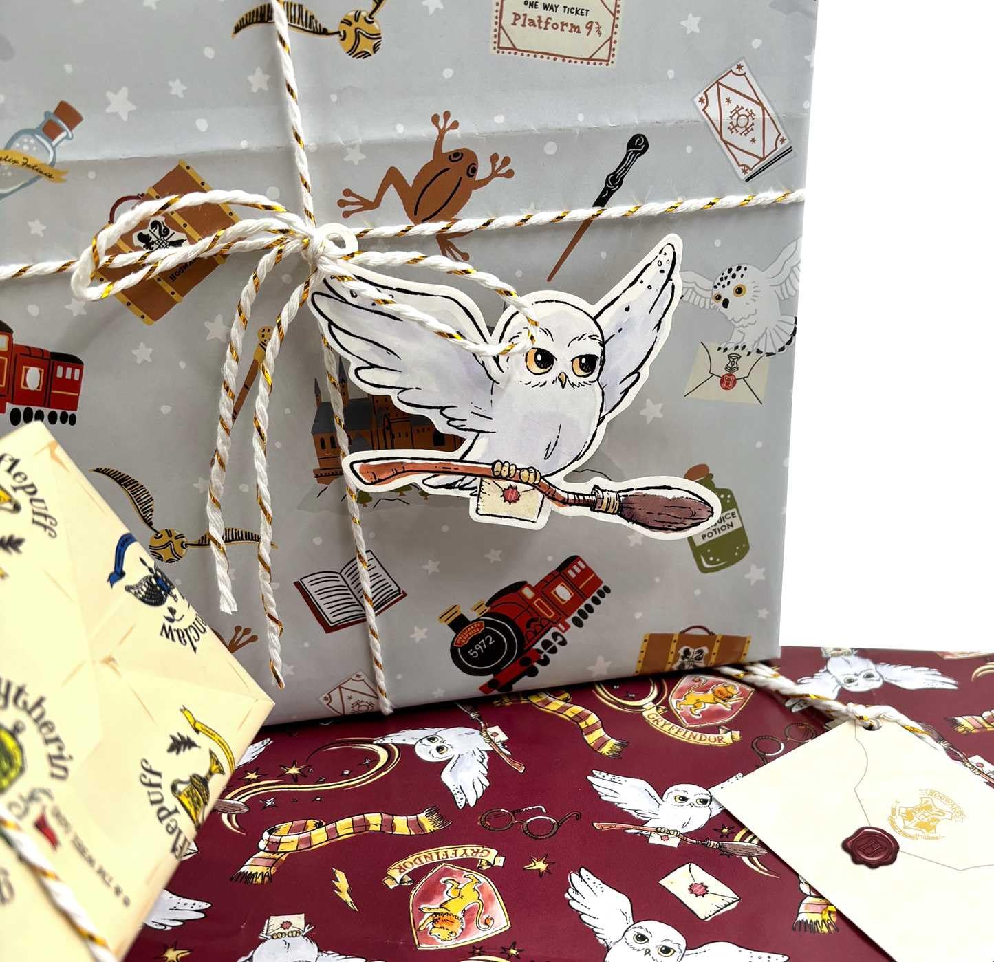 Harry Potter Hogwarts gift wrap with Hedwig owl cutout on gray wrapping paper featuring Platform 9¾ ticket and magical icons, perfect for wizard-themed birthday party supplies