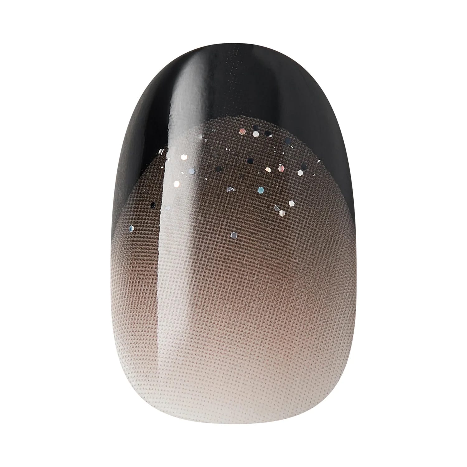 Close-up of Kiss x Wicked For Good black to nude ombre press-on nail with silver glitter; short oval fake nails with glow-in-the-dark effect