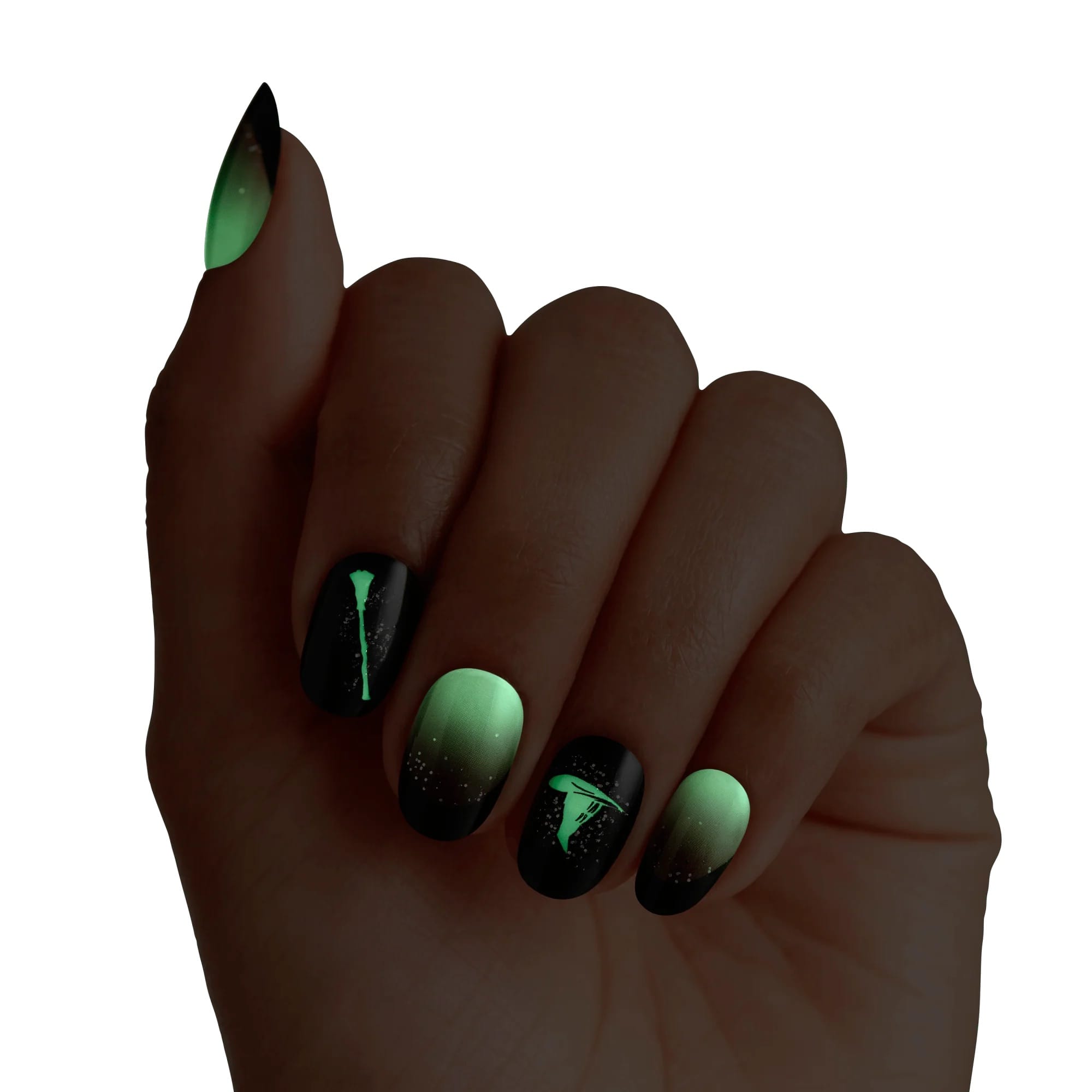 Hand model showing Kiss x Wicked For Good Elphaba Own Your Power press-on nails glowing green in the dark; Elphaba witch hat and ombre nails with glow-in-dark effect; perfect for Wicked theme party