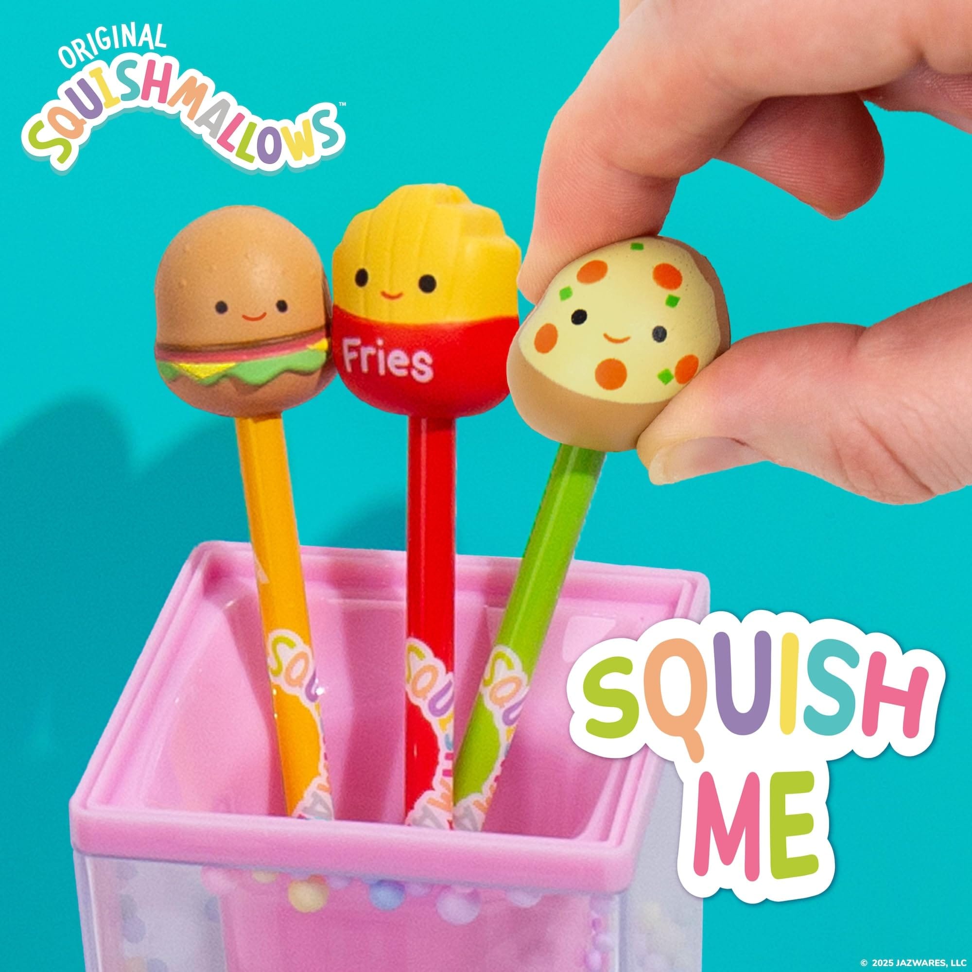 Hand squishing Squishmallows Pep pizza pen topper; Carl, Floyd, and Pep novelty squishy ballpoint pens displayed in pink pencil cup