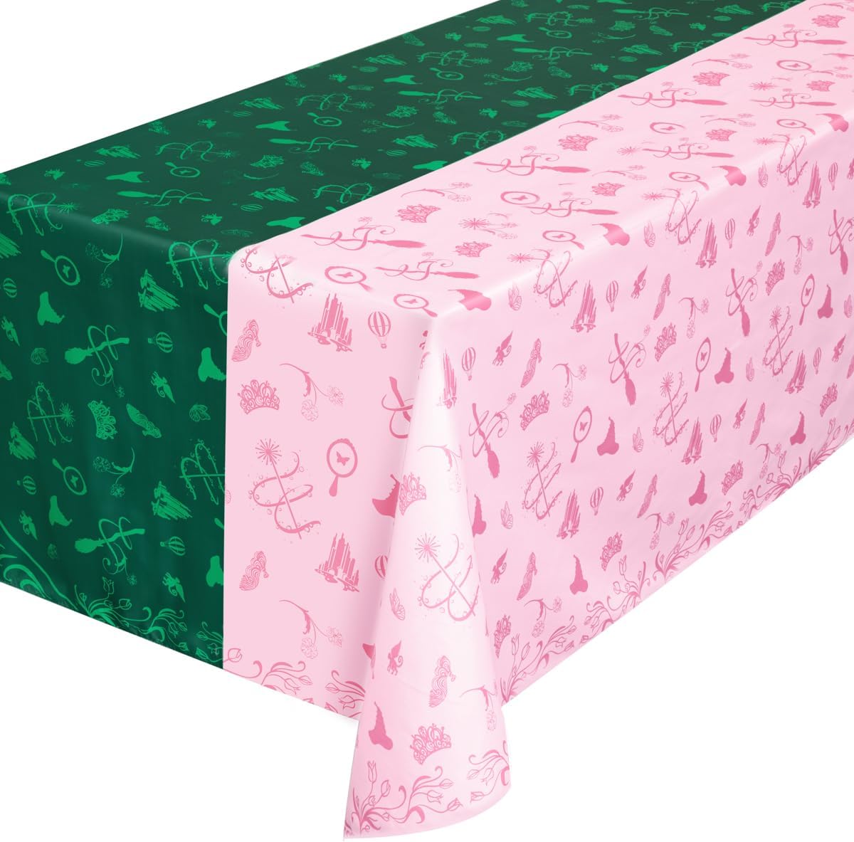 Wicked party tablecloth on table showing half green witch hat and half pink crown design with Emerald City motifs