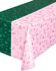 Wicked party tablecloth on table showing half green witch hat and half pink crown design with Emerald City motifs