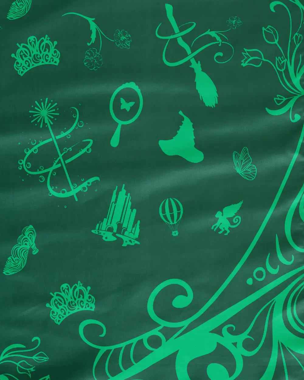 Wicked tablecloth green Elphaba side closeup showing witch hat broom butterfly crown and Emerald City pattern