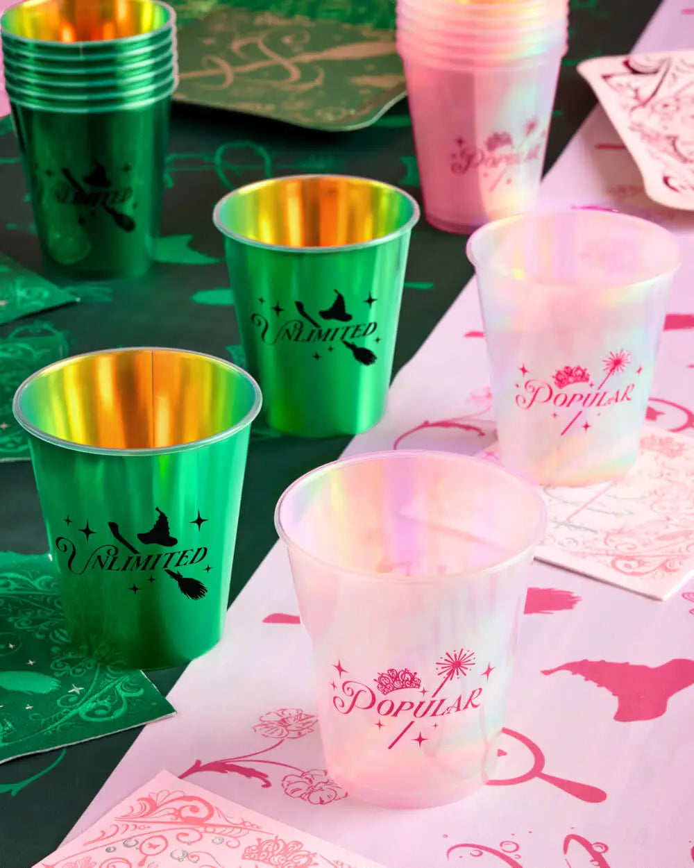 Wicked themed Popular and Unlimited party cups styled on table with matching pink and green napkins for party table decor