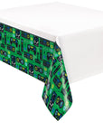 A green and black disposable plastic table cover featuring a pattern of video game controllers on a bright green border, with a white rectangular table in the background.